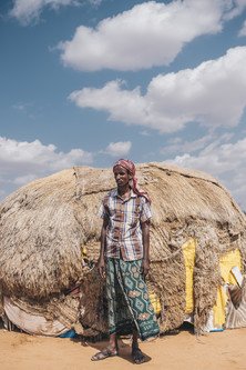 Omar Abdi, 40, stands in front of a house donated by the community where he now lives. A pastoralist, Abdi was forced to move with his wife and 8 children after most of their livestock perished in the drought.